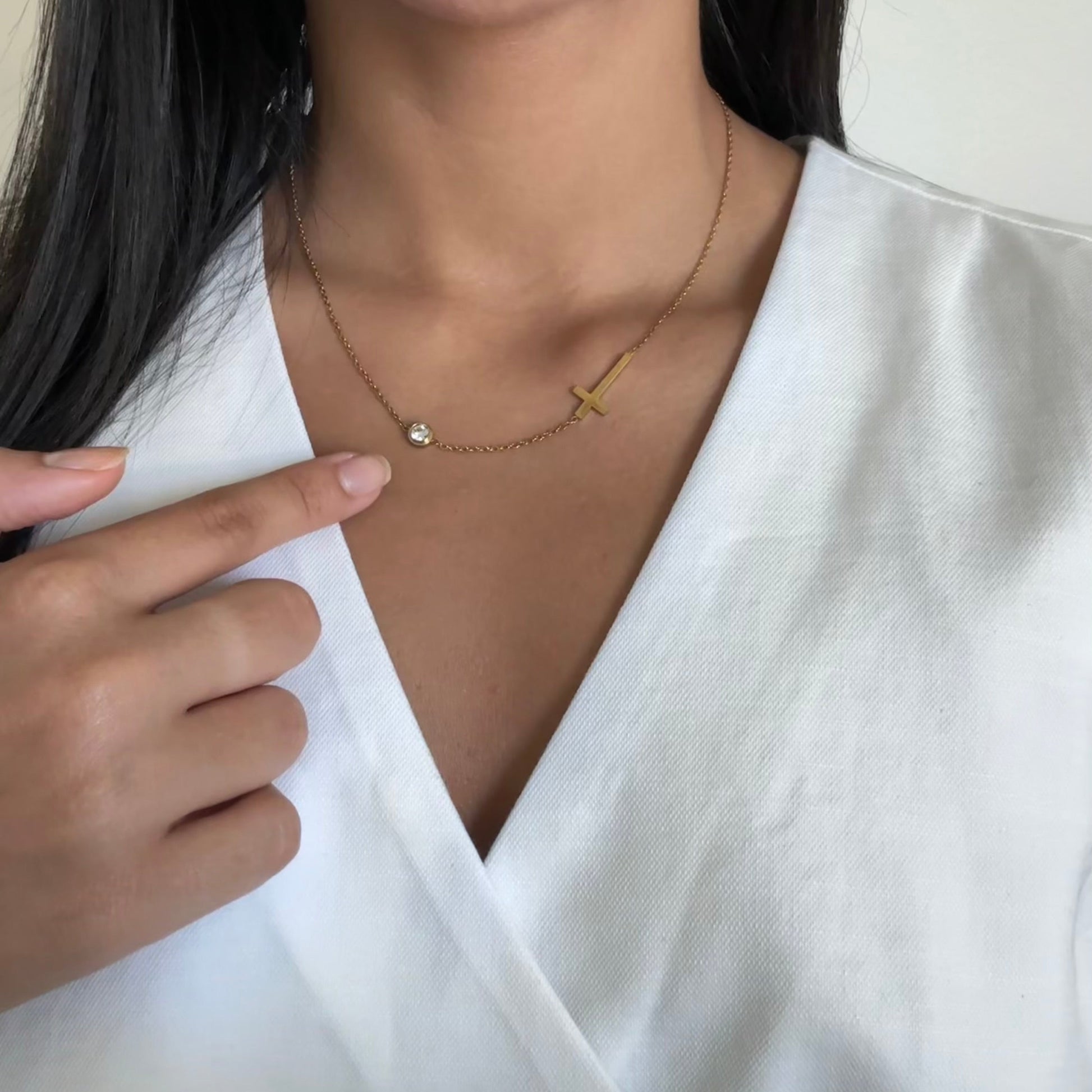 Close-up of gold cross pendant – Liora necklace, stainless steel