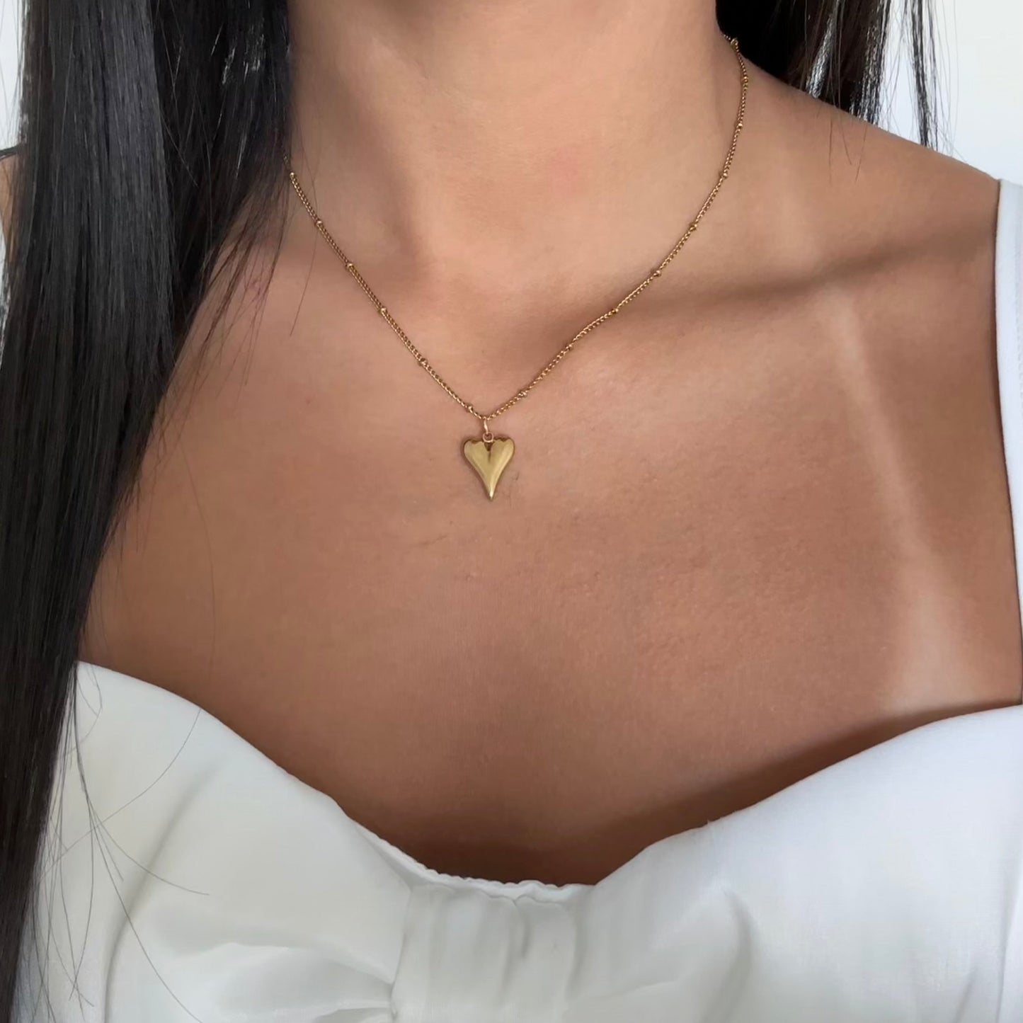 Model wearing Amora gold necklace – bold, romantic heart jewelry for daily wear